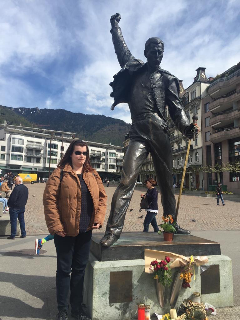 Elena posa sorridente a fianco alla statua di Freddie mercuri nella piazza di Montreux in Svizzera