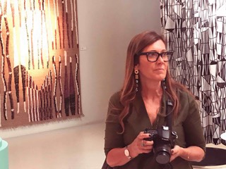 Nella foto Daniela stringe tra le mani la sua macchina fotografica, compagna di mille avventure in giro per il mondo