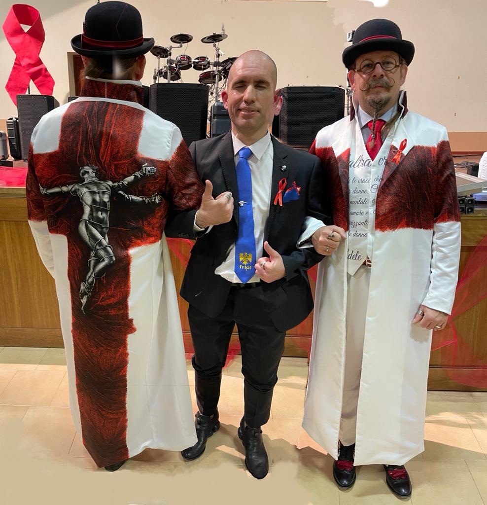 Roberto è al centro in abito da sera tra 2 Mister JP: a sinistra Mister JP è di schiena per mostrare il suo abito speciale mentre a destra è di fronte e sorride alla fotocamera