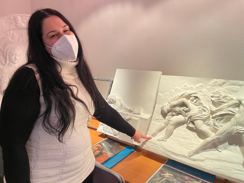 La tiflologa Debora Tramentozzi posa davanti al bassorilievo prospettico di Atalanta e Ippomene